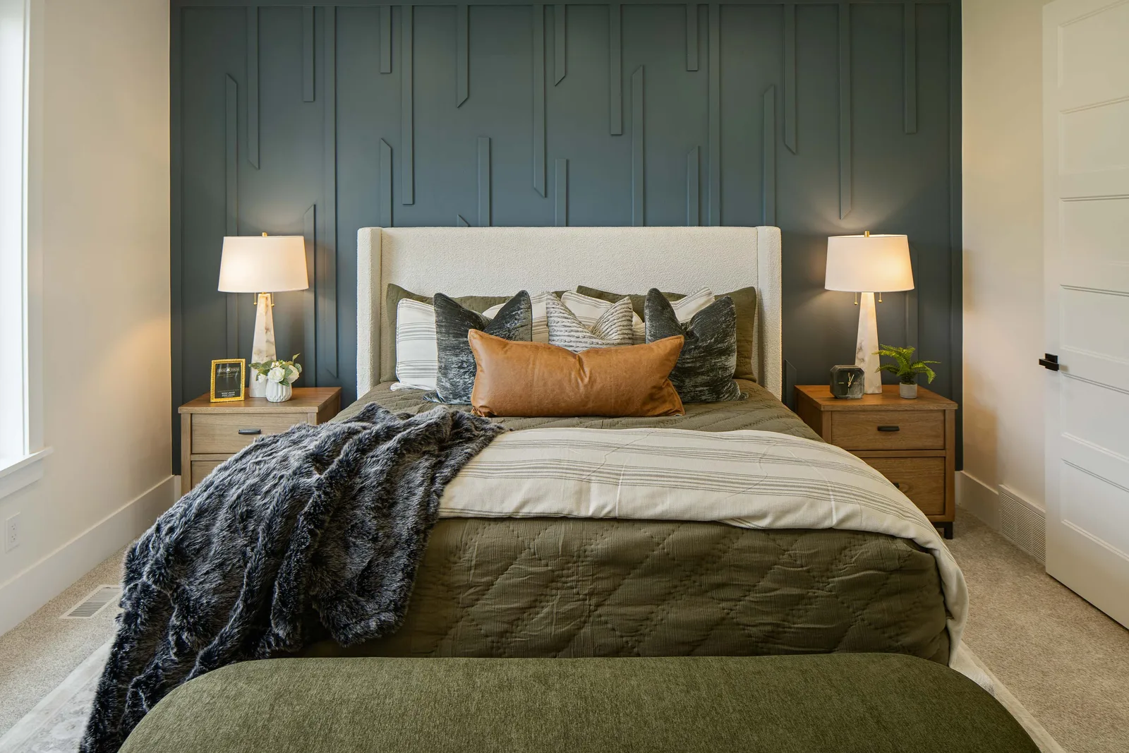 Blue board-and-batten behind a boucle bed