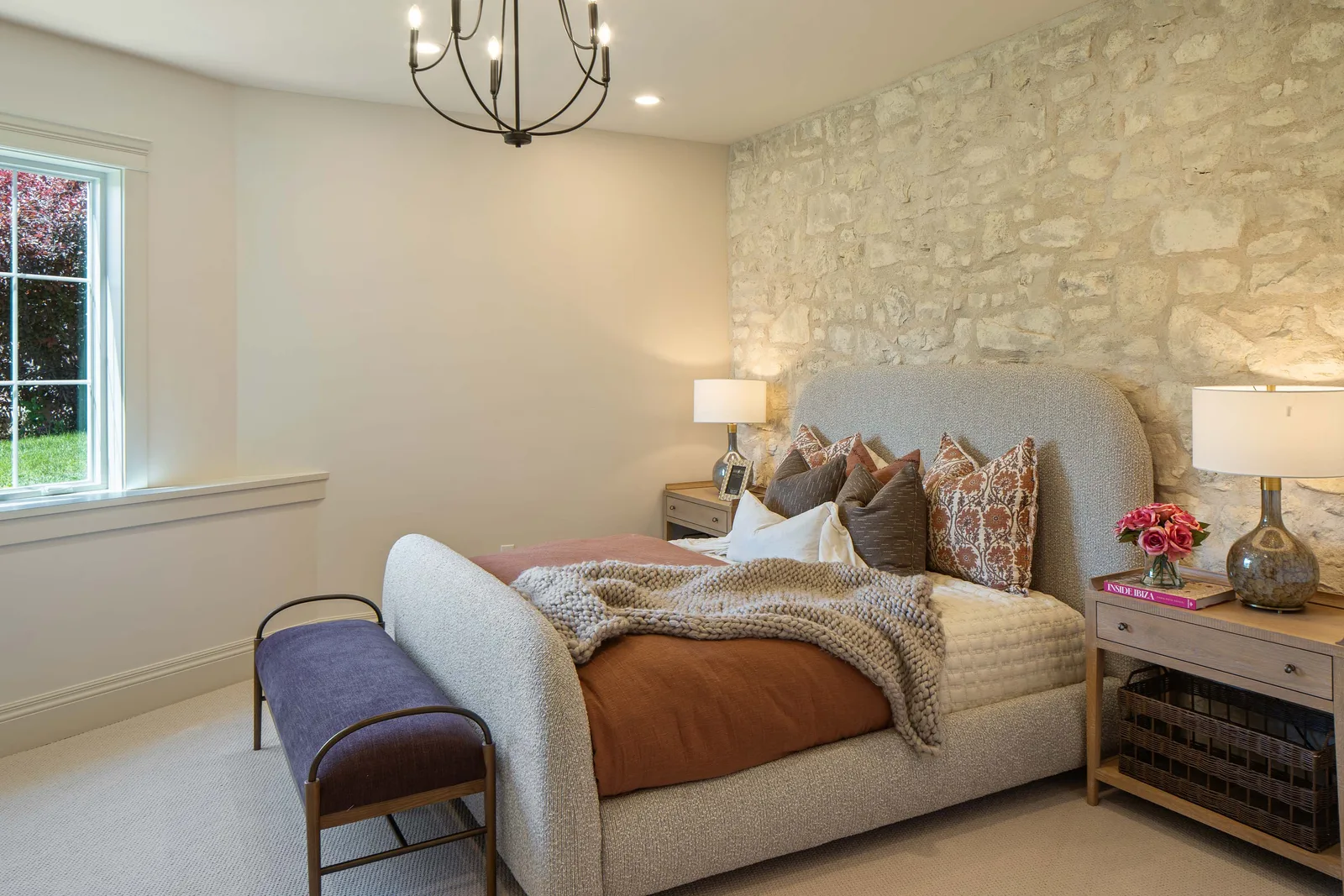 A bedroom against a stone wall
