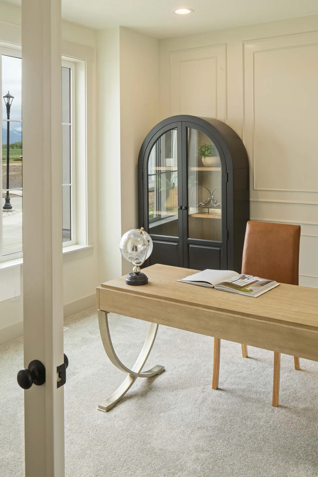 An oak desk against black paneling